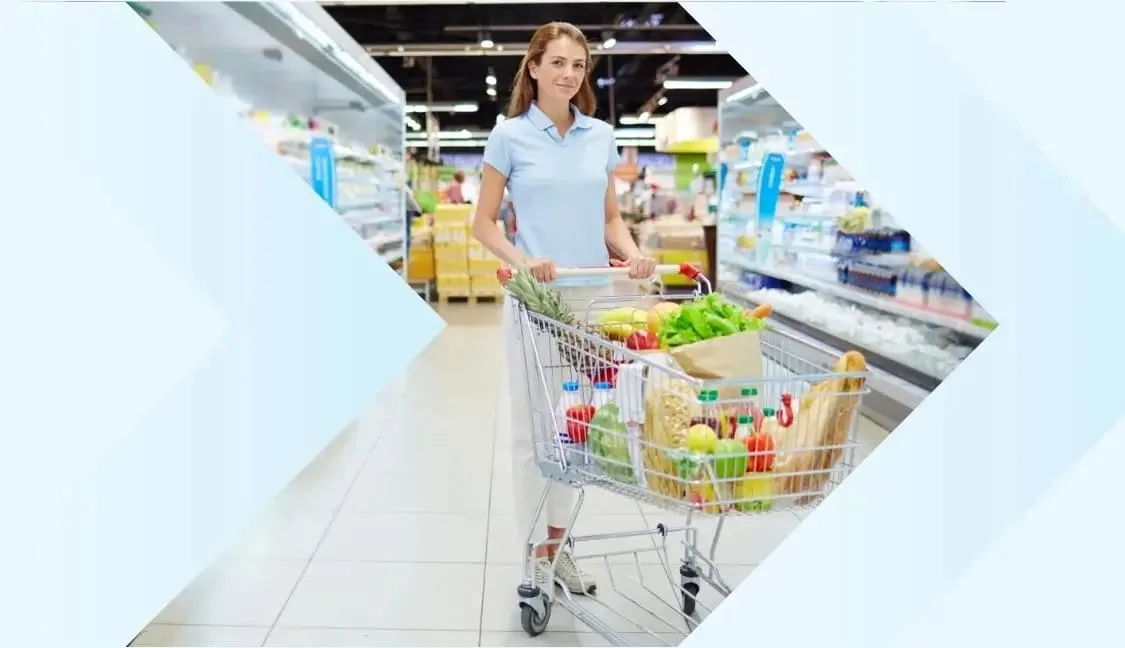 Happy woman shopping in a supermarket with a cart full of fresh groceries, including fruits, vegetables, and packaged goods. Perfect for online grocery stores, FMCG retail, and supermarket shopping experiences.